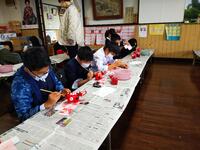 赤ベコの絵付けに集中する子どもたちです。