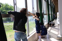 体育館ギャラリーの窓を拭く３年生と保護者